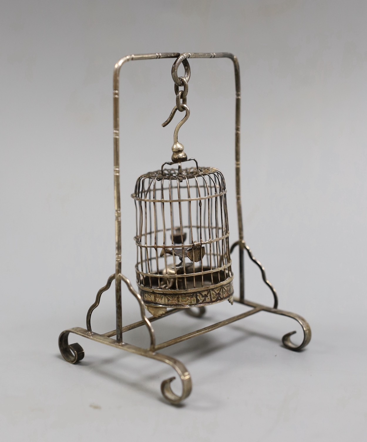 A Chinese white metal miniature model of a bird cage and stand, height 11.8cm, and a miniature teapot.